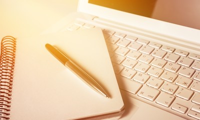 Canvas Print - Laptop with notebook and pen. Isolated  background