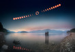 Woman and girl standing in lake watching solar eclipse