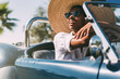 © DavidPrado - Black woman driving a vintage convertible car