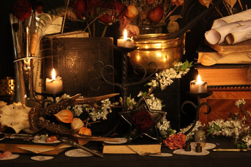 Black candle Magic Ritual. Antique Magic Book. Witchcraft  Peacock feathers and candle background.