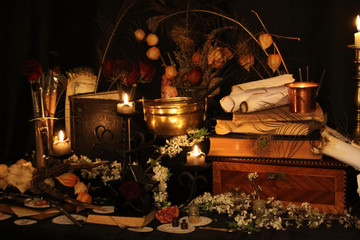 Black candle Magic Ritual. Antique Magic Book. Witchcraft  Peacock feathers and candle background.