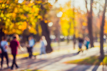 Blurred background of a central park with people walking with their families
