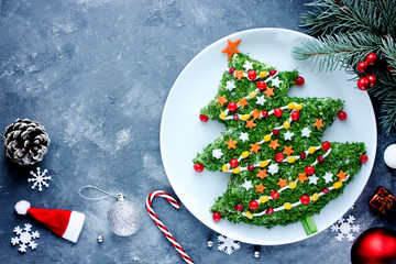 Canvas Print - Christmas new year meal idea - creative appetizer salad like a christmas tree with festive decoration from greens and vegetables