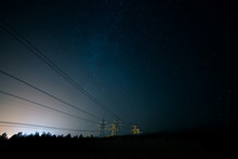 Incredible Night Sky With Stars, Milky Way Passing Over Power Line In Long Exposure Timelapse. Beautiful Panorama View. Nature In The Countryside. Astro Photography