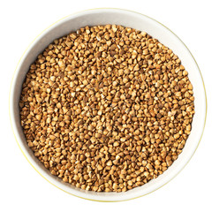 Wall Mural - Bowl of Dry Raw Buckwheat Grains Isolated on White Background. Russian Kasha or Uncooked Pseudocereal Buck Wheat with Clipping Path