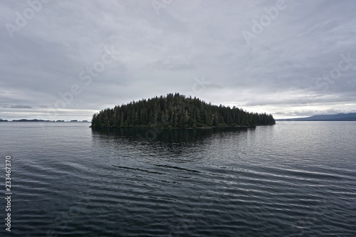 Fotografie, Obraz Sitka, Alaska, USA: Dawn on the horizon and thick clouds in the sky above a small isolated island in the Eastern Channel