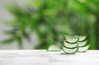 Slices of aloe vera on table against blurred background. Space for text
