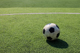 Fototapeta Sport - Football on artificial turf. It is for green background in a stadium