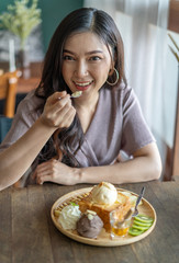 Wall Mural - woman eating honey toast, sweet dessert in cafe