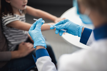 Wall Mural - Concept of professional immunizations in healthcare immune system. Close up portrait of medical syringe in hands of doctor ready to make vaccination