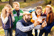 © zinkevych - Team of explorers. Joyful cute children standing behind their teacher while looking at him taking photos