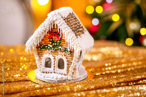Gingerbread house in front of defocused lights of Christmas