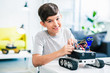 Nice smiling little boy constructing modern robot