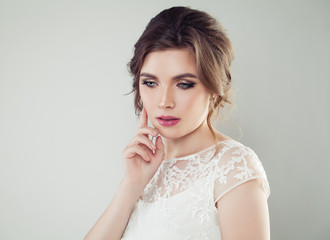 Young woman with makeup and bridal hairstyle. Pretty woman fiancee looking down, face closeup