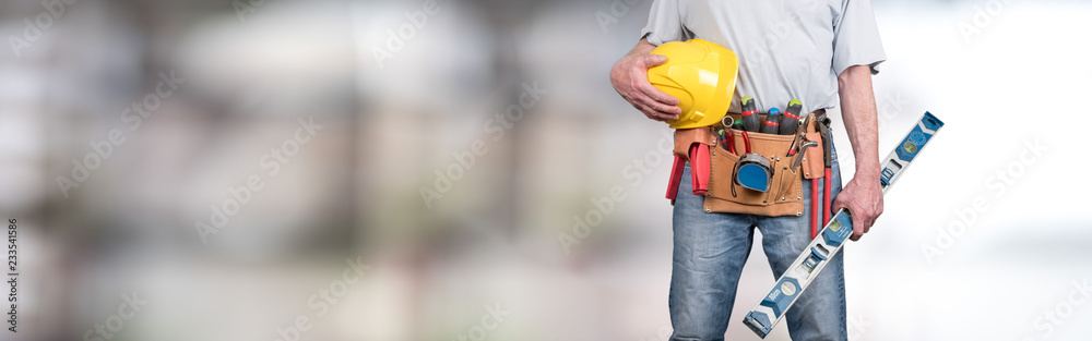 Building worker with tool belt and helmet - obrazy, fototapety, plakaty 