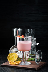 Alcoholic cocktail with strawberry liqueur and cream in a glass. On a wooden background. Top view. Free copy space.