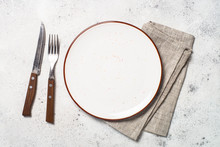 White Craft Plate, Cutlery And Napkin On White Stone Table. 