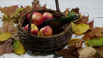 Wall Mural - autumn leaves with bottle of cider and  apples in the basket