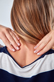Fototapeta  - Young woman with upper back pain holding spine.