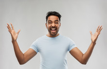 Success, Emotion And Expression Concept - Happy Young Indian Man Celebrating Victory Over Grey Background
