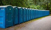Portable Mobile Toilets In The Park. A Line Of Chemical WC Cabins For A Festival Event, In The Woods