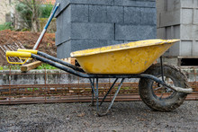 Yellow Wheelbarrow  In Construction Site After Use.
