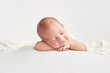 Leinwandbild Motiv Cute newborn baby lies swaddled in a white blanket. Baby goods packaging template. Closeup portrait of newborn baby with smile on face. Healthy and medical concept. 
