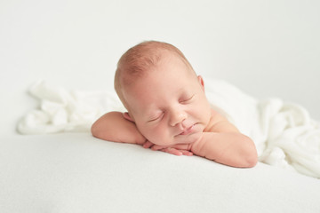 cute newborn baby lies swaddled in a white blanket. baby goods packaging template. closeup portrait 
