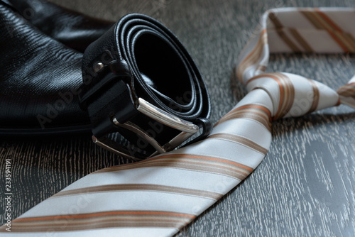 Fotografía Men's accessory set black boots, leather belt and tie on grey wooden background