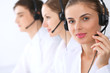 © rogerphoto - Call center operators at work. Focus at beautiful business woman in headset