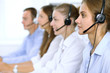 © rogerphoto - Call center operator in headset while consulting client. Telemarketing or phone sales
