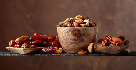 Various dried fruits and nuts in wooden dish.