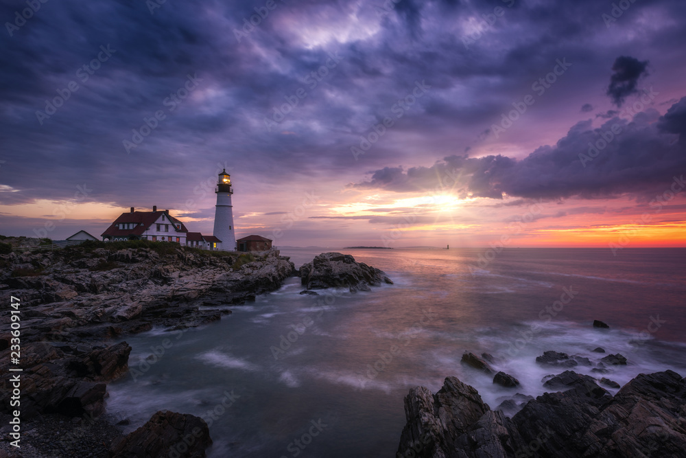 Sunshine breaking through dark clouds at Portland Head Lighthouse in Maine - obrazy, fototapety, plakaty 