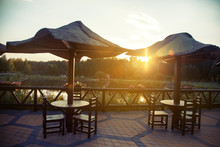A Cozy Cafe On The Lake With Chairs, Tables And An Umbrella With A Magnificent View. Travel, Excursion, Rest, Relaxation