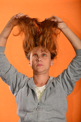 Wall Mural - The girl holds her hair up and they bloom on the fly on a yellow background.