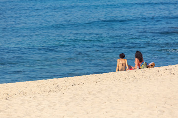 View of two women, alone on the beach, enjoying sunbathing on the beach of Leca da Palmeira, Portugal