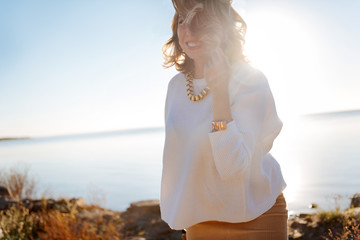 Smiling pregnant woman walking near the water