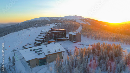 Photographie AERIAL: Flying around hilltop skiing resort surrounded by ski slopes in winter