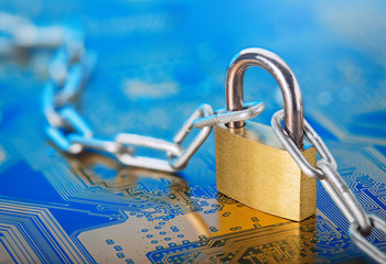 Wall Mural - Padlock with chain on the electronic printed circuit board.  IT and net protection, computer safety. Network Security, data security and antivirus protection PC.