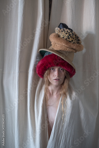 Fotografie, Obraz Natural looking actress model behind curtain with hats