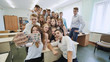 © Довидович Михаил - Young happy cheerful students making selfie in school class.