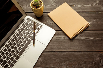 Office table with blank notebook and laptop / Coffee cup