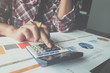 © wichayada - man using calculator while working for financial documents