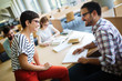 © NDABCREATIVITY - Happy young university students studying with books in library