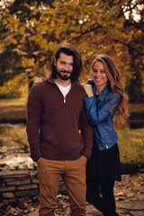 Couple in autumn season colored park enjoying outdoors.