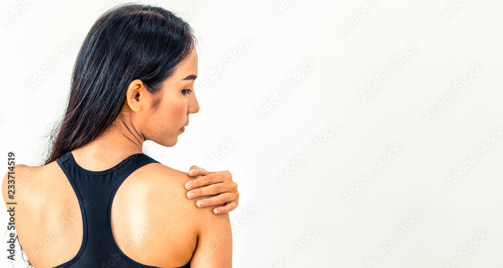 Sporty woman touching shoulder in fitness gym. Healthy lifestyle concept.