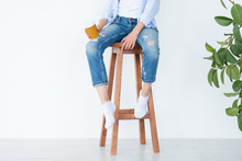 Woman Sitting On High Wooden Stool With Coffee Cup. Relaxed Leisure And Casual Lifestyle. White Background.