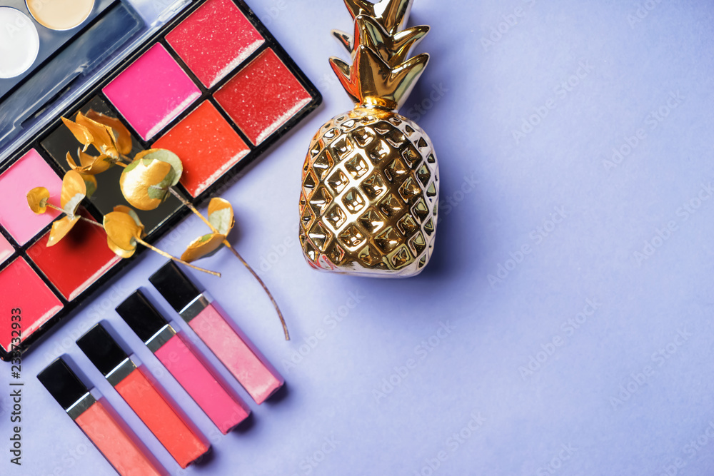 Composition with different lipsticks and pineapple on color background