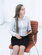 young business woman with smartphone sitting on an office chair