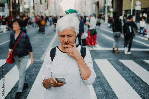 Fotografía .Caucasian middle-aged woman traveling through Japan. Touring the city of Tokyo